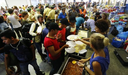 Volunteers distribute food to the refugees in Munich central station