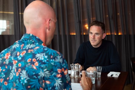 Andrew and Oliver sit at a restaurant table, chatting