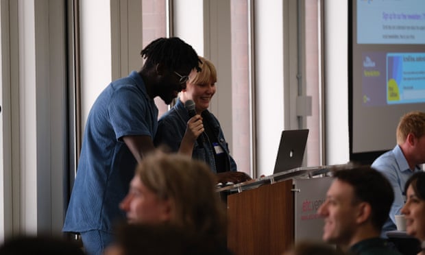 Abo Akintunde (left) and Georgia Ellis (right) speak at a lectern at the Product and Engineering away day 2022