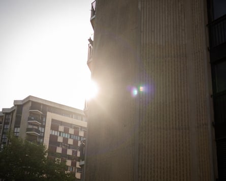 An apartment building mostly obscures the view of the sun