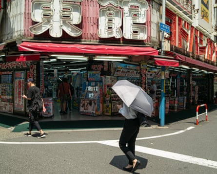 A pedestrian shields herself from the sun in Tokyo.