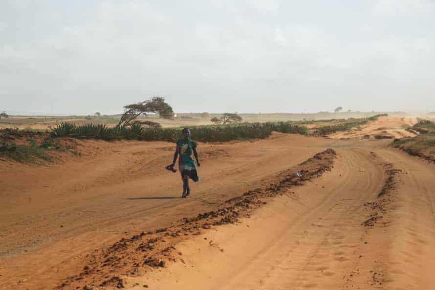A person walks along a road in a region of Madagascar that is prone to drought