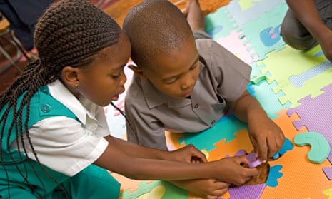 Young girl and boy in South Africa doing a floor puzzle.