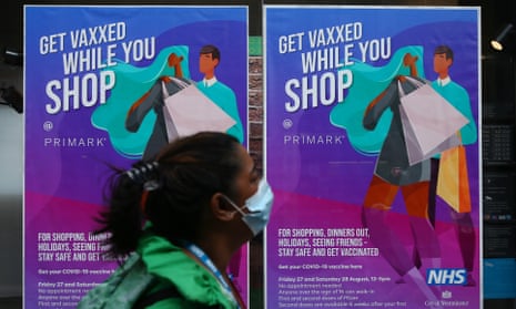 A pedestrian walks past a poster advertising in-store vaccinations at Primark on Oxford Street, London.