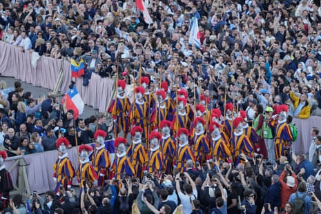 Swis guards march as white smoke billows from the chimney of the Sistine Chapel where 133 cardinals are gathering on the second day of the conclave to elect a successor to late Pope Francis.