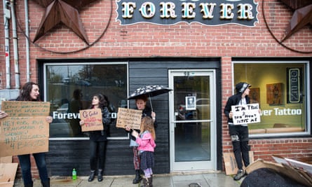 Protesters stand outside Forever Tattoo in Asheville, North Carolina, on Thursday,.