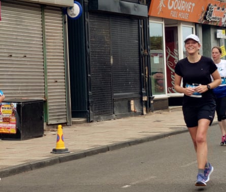 Caroline Eden running a half-marathon on an urban street in East Lothian, Scotland.