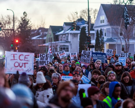 People demonstrate against ICE during a vigil honoring a woman who was shot and killed by an immigration officer.