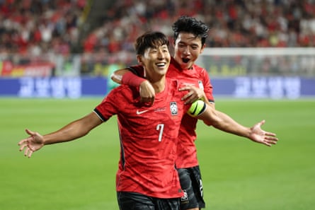Son Heung-min celebrates with arms outstretched after scoring a goal for South Korea.