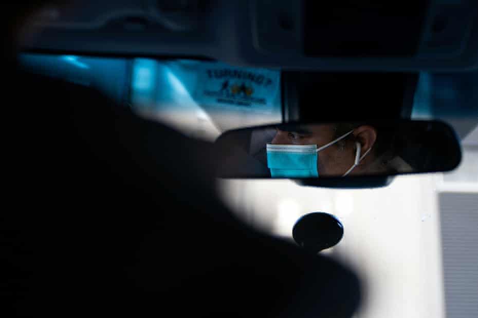 An Uber driver in a surgical mask is seen in a mirror in the Manhattan borough following the outbreak of the coronavirus disease.