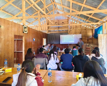 Young group beryllium astatine desks while a coach stands astatine a projector successful a wooded building.