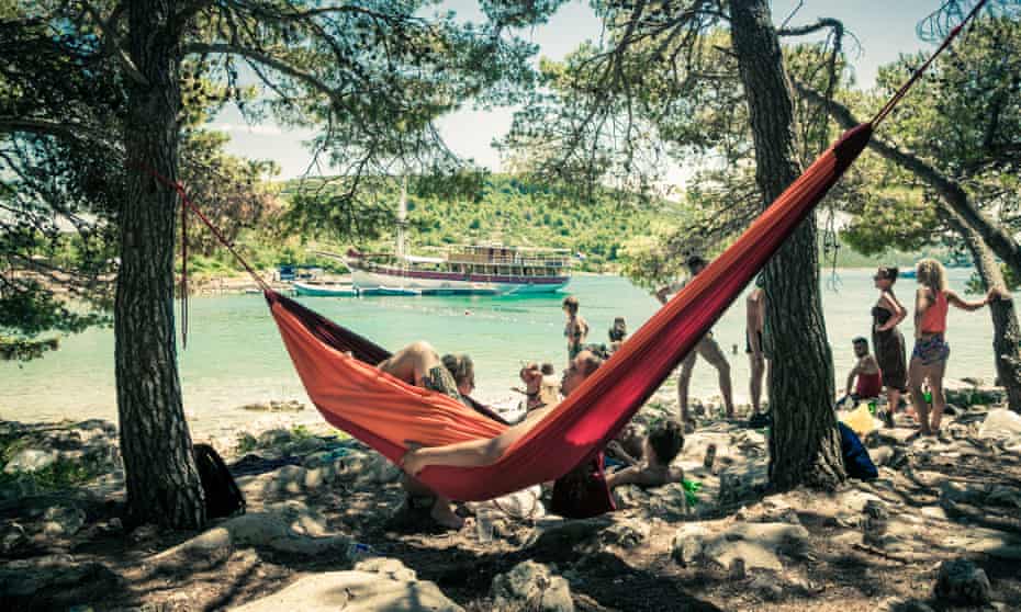 A festivalgoer relaxes in a hammock by the waterfront in a publicity image for the Love International festival at the Garden Resort in Tisno.