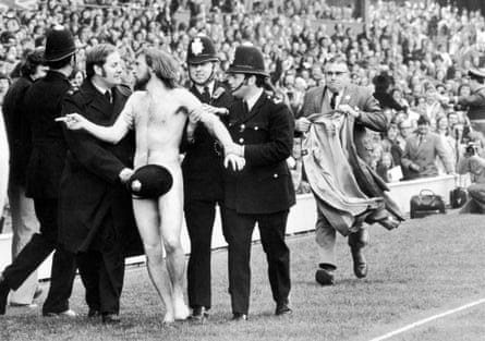 Streaker Michael O’Brien sprints into the arms of awaiting policemen during half time at the Rugby Union International match at Twickenham. 20/04/1974