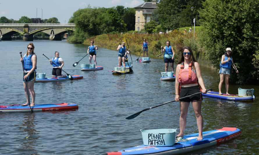 Planet Patrol's Lizzie Carr on her paddleboard, with a group of volunteers.