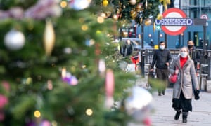 Pedestrians wear masks as they walk past Christmas decorations in London's Knightbridge.