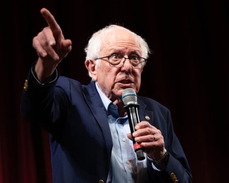 Bernie Sanders gesturing with raised arm during a town hall on AI at Stanford