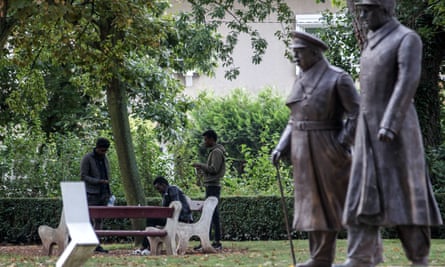 Migrants from Sudan sit near statues of Winston Churchill and Charles de Gaulle in a public park in Calais.