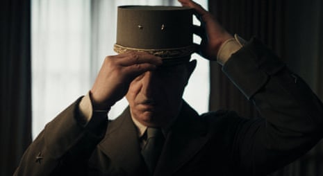 Simon Abkarian, in costume as De Gaulle, donning his famous kepi hat