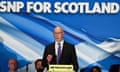 John Swinney speaking under a stage banner reading 'SNP for Scotland'