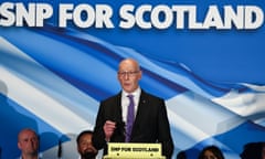 John Swinney speaking under a stage banner reading 'SNP for Scotland'
