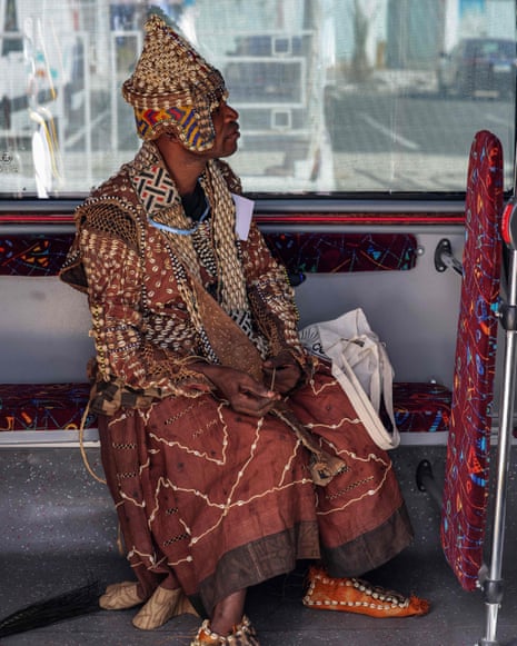A delegate wearing traditional clothing rides a bus on the way to the Cop27 climate conference.