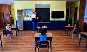 Children wearing masks and at desks spaced apart attend a summer school session in Monterey Park, California, on 9 July. 