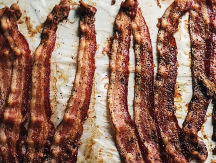 Long bacon rashers on a baking tray.