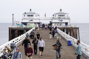 People walk on the Malibu Pier on Sunday as businesses reopen.