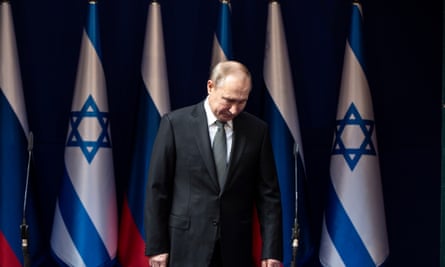 الرئيس الروسي فلاديمير بوتين أمام الأعلام الإسرائيلية.
