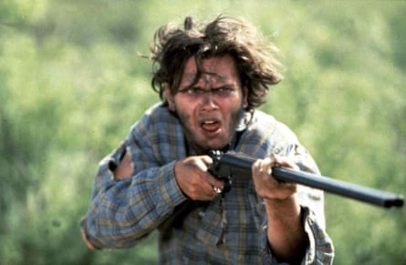 A boy in a plaid shirt holding a rifle