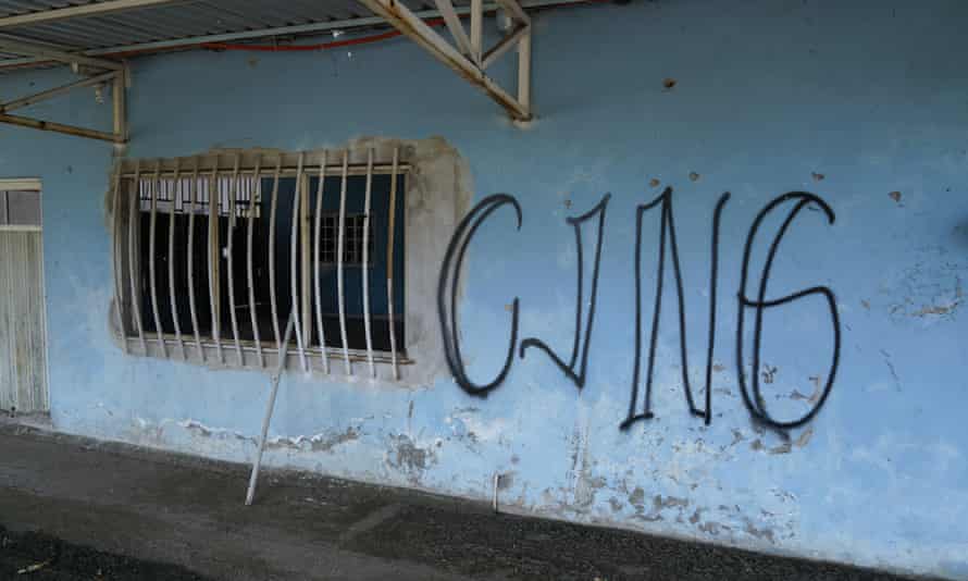 The letters CJNG, for Jalisco New Generation cartel, is scrawled on the facade of an abandoned home, in El Limoncito, in the Michoacán state of Mexico.