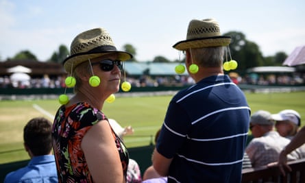 Fans wear tennis-themed sun hats as they wait for the play to start at Wimbledon