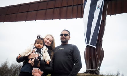 Couple pose in front of Angel of the North statue with daughter