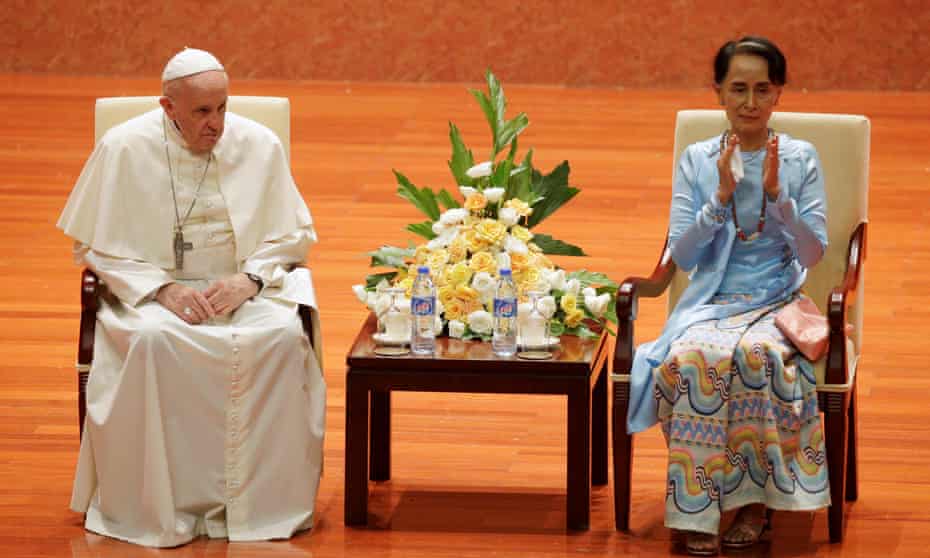 Aung San Suu Kyi applauds as she sits next to Pope Francis.