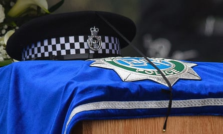 A policeman’s hat sits on top of the coffin of PC David Phillips