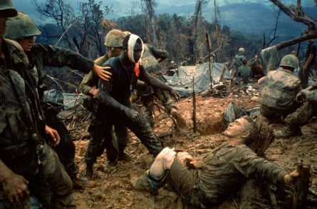 Wounded Marine Gunnery Sgt. Jeremiah Purdie (C) being led past stricken comrade after fierce firefight for control of Hill 484 south of the DMZ.Army, Vietnam, 1966