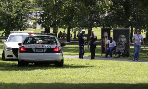 A police officer speaks to a man walking in New Haven Green park on 15 August. At least 95 people overdosed on the synthetic drug in the city over the course of two days.