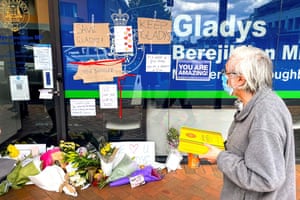 A man looks at flowers and signs placed by members of the public outside the local office of former NSW premier Gladys Berejiklian on 2 October.