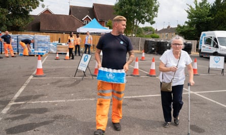 Staff from Thames Water give out bottled water to residents who have no water after a problem at the water treatment works.