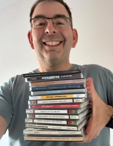 Neil Cumming holds a stack of his CDs in one hand.