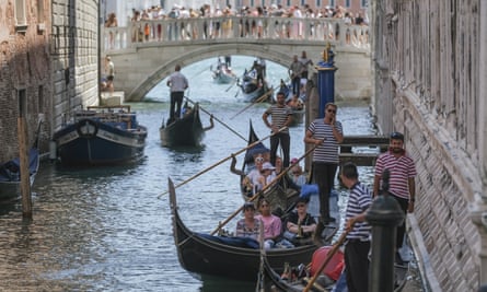 Crowded gondolas jostle for room in a narrow, ancient canal