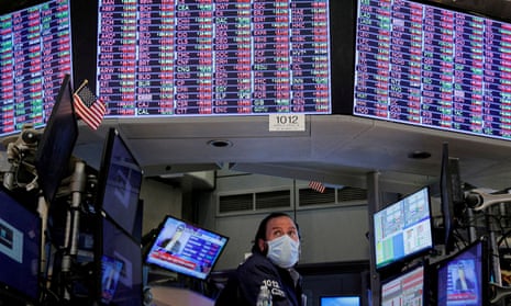 A specialist trader, surrounded by monitors and TV screens, works inside a booth on the floor of the New York Stock Exchange.