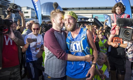 Smith celebrates with his partner, Kyle, after completing his marathon challenge.