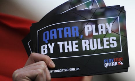 A fan holds a leaflet telling Qatar to play by the rules
