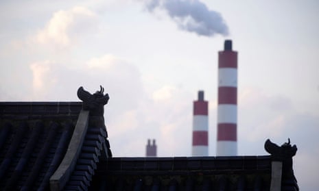 Chimneys of a coal-fired power plant are seen behind a gate in Shanghai, China.