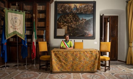 Giorgio Angeleri, mayor of Orta San Giulio in Italy, sitting behind a desk in the town hall.