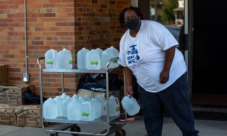 A volunteer prepares gallons of water to be distributed to residents at the Harbor Harvest Urban Ministries in Benton Harbor.