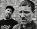 Andrew Fearn (left) and Jason Williamson of Sleaford Mods pictured standing against a wall in a black and white photo.