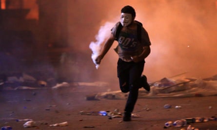 A masked demonstrator with a teargas canister amid clashes with security forces in the centre of Beirut