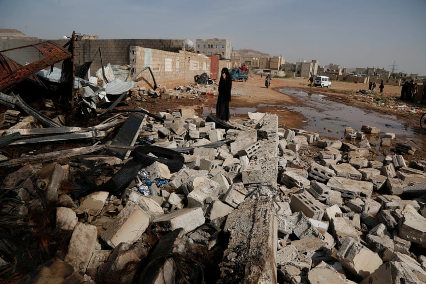 A woman stands near the wreckage of a store of oil and tyres in Sana’a after it was targeted by airstrikes carried out by the Saudi-led coalition in July 2020.